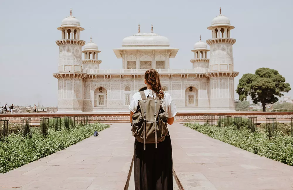 junge Frau mit Rucksack steht vor dem Itimad-ud-Daula-Mausoleum