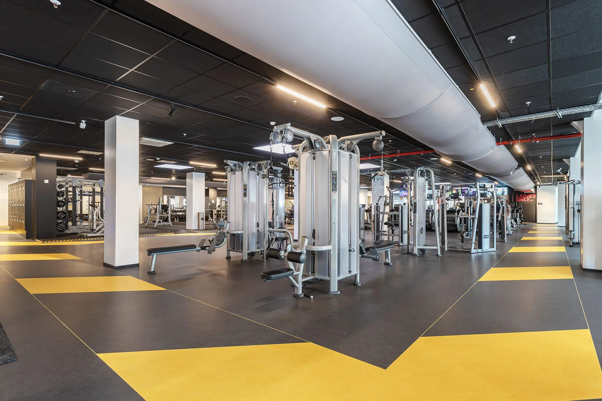 Trainingsfläche in einem Fitnessstudio mit einer schwarz-gelben Leitlinie auf dem Boden